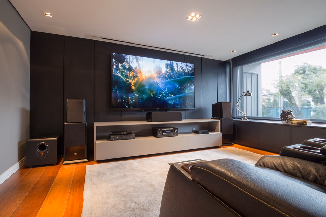 Sala de home theater dedicada, com acústica e projeção calibradas